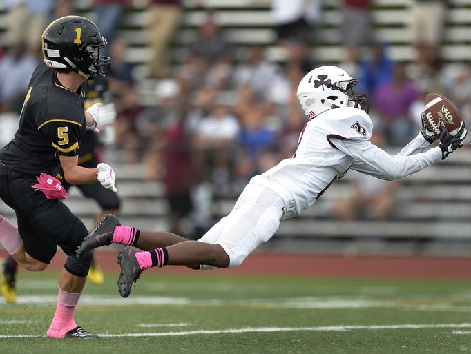 Aquinas’ Kobe McNair, right, makes a diving catch in