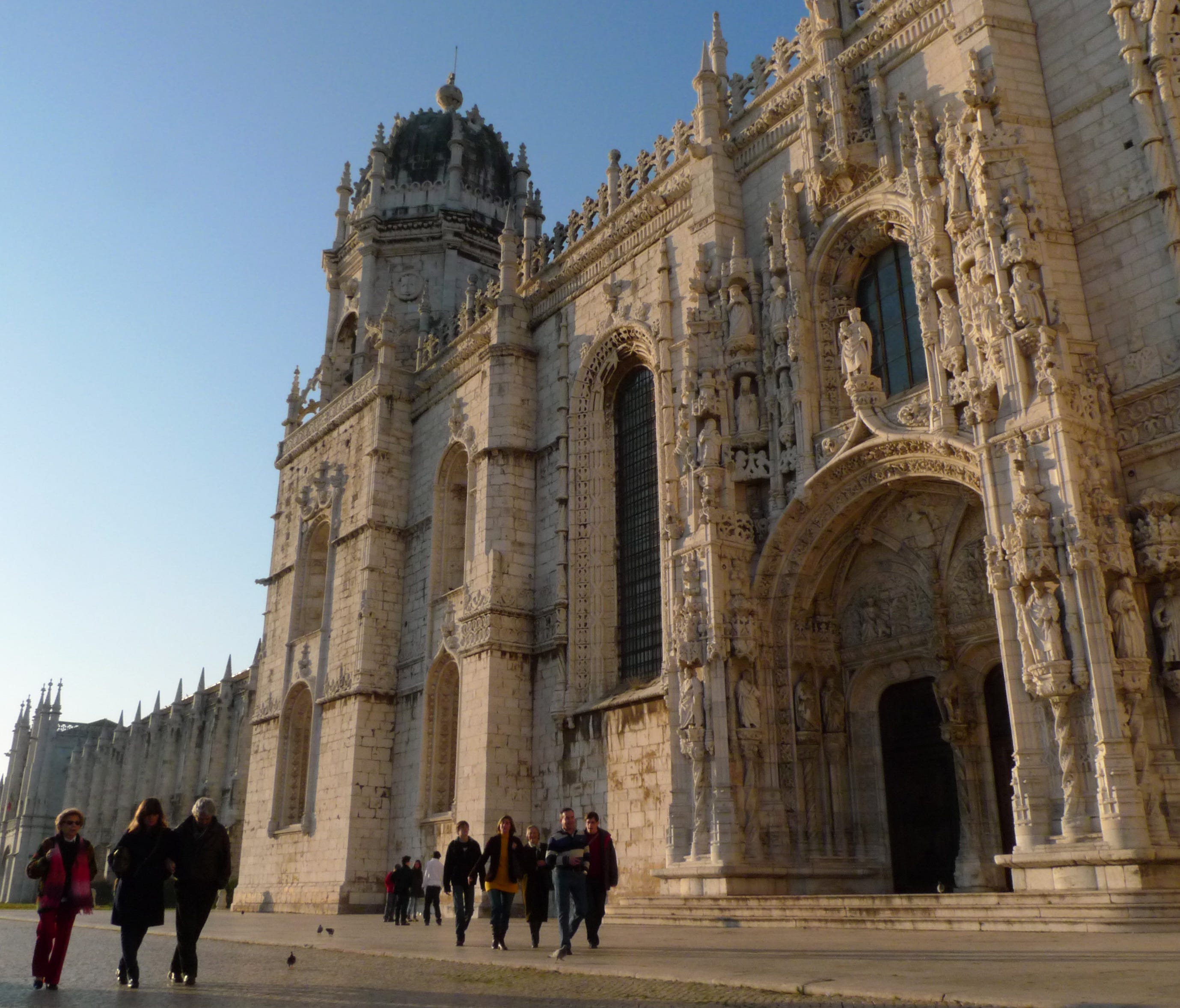 People walk past the 16th century Jeronimos Monastery in Lisbon.