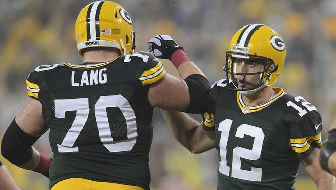 Green Bay Packers Green Bay Packers quarterback Aaron Rodgers (12) celebrates his touchdown pass to Randall Cobb with lineman T. J. Lang (70) in the first quarter against the Minnesota Vikings at Lambeau Field Thursday, October 2, 2014.