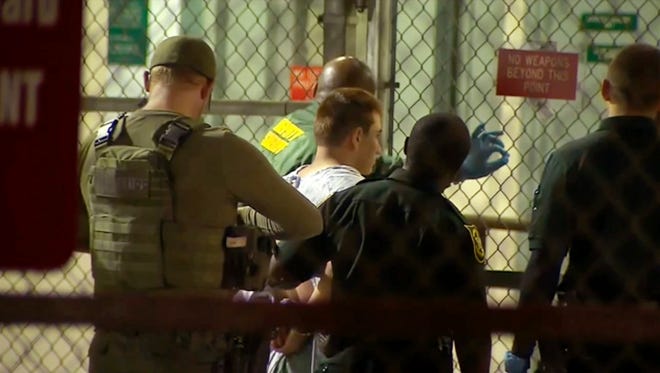 In this frame grab from video provided by WPLG-TV,  police take Nikolas Cruz into Broward County jail on Thursday, Feb. 15, 2018 in Fort Lauderdale, Fla.  Cruz was charged with 17 counts of premeditated murder Thursday morning after being questioned for hours by state and federal authorities.