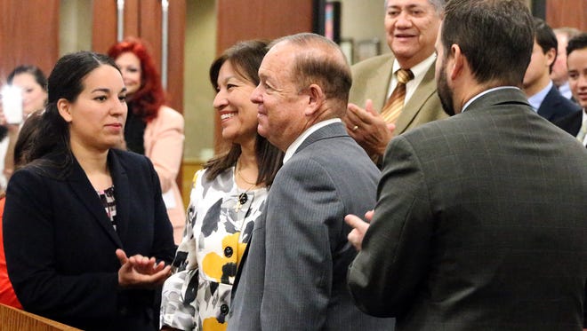 Judge William “Bill” Moody, center, is flanked by his family while receiving applause after county judge Veronica Escobar read a resolution honoring him for over 30 years of elected service as judge of the 34th District Court Monday at County Commissioners Court. Escobar said Moody has been elected eight times to the 34th District Court bench and has heard over 500 felony and civil cases as well as five capital murder cases. Moody led the effort to raise juror pay to $40 per day in El Paso County in 2001 and later was lead witness before the state legislature to increase juror pay to $40 statewide in 2005, she said. His family includes from left: daughter Emily Moody, wife Maggie Morales-Moody and son State Rep. Joe Moody, far right.