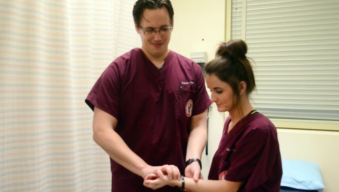 William Carey University medical students Nicholas Hahn and Cecilia Lawn practice for their class at Southern Miss Tuesday. Classes were relocated to the USM campus due to tornado damage on the William Carey campus.