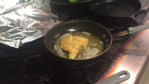 Cracker crumb-breaded fish sizzles in a pan at Carmelo's Italian Restaurant.