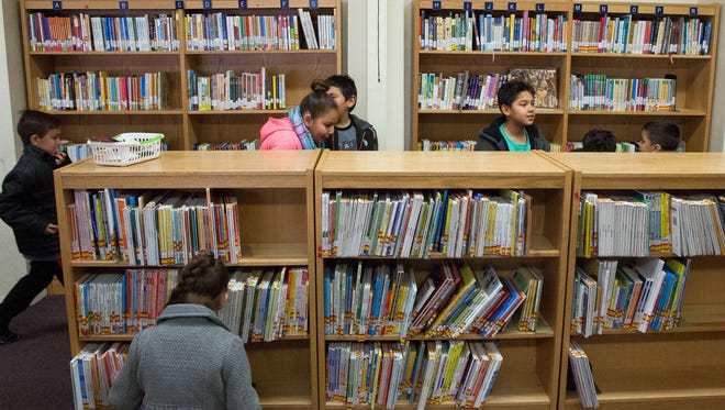 Second- and third-grade students rush into the library at Central Elementary School looking for books to check out Wednesday January 24, 2018. Students returned to Central earlier in the week after the school was cleaned of mold.