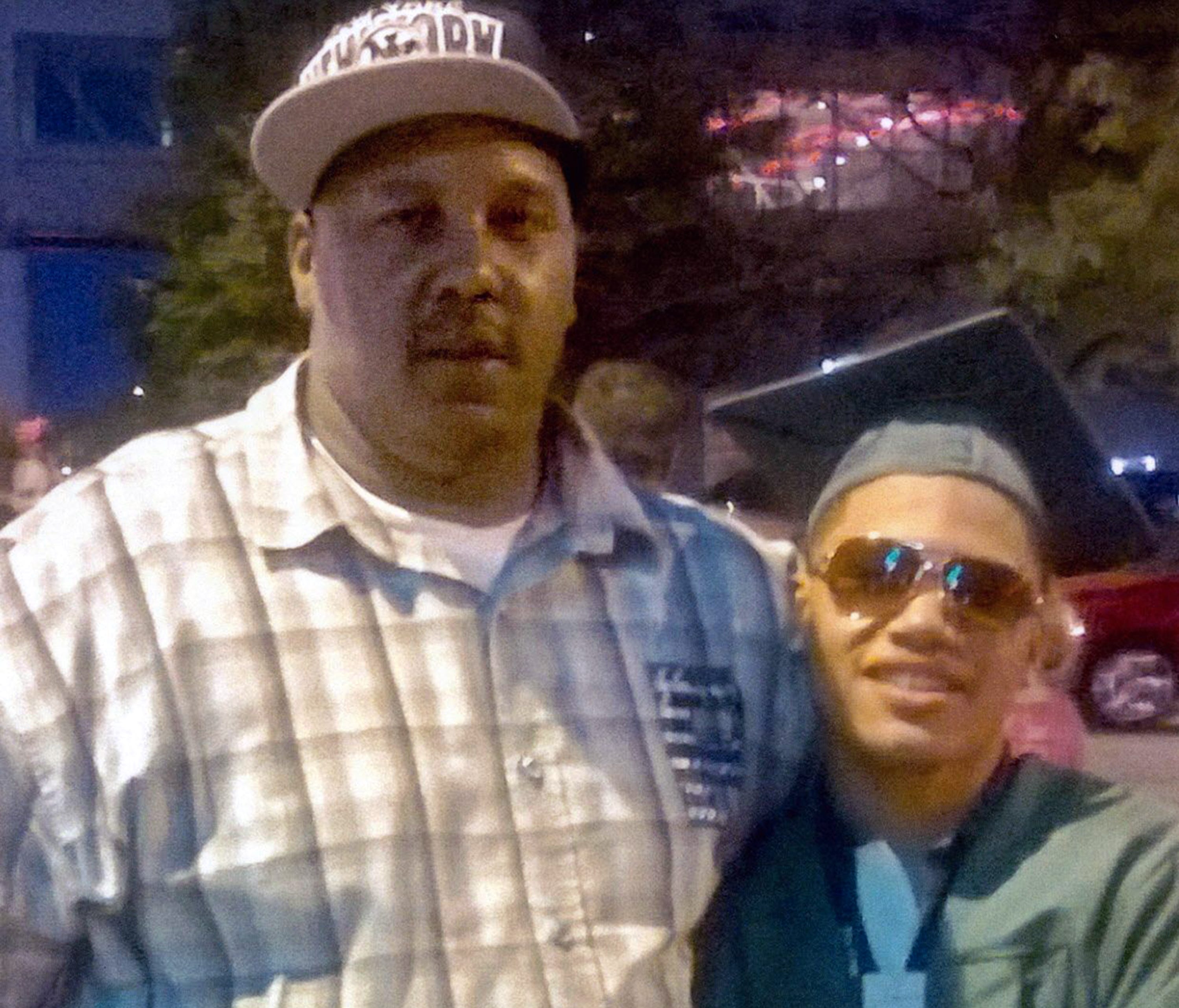 Terrill Thomas, left, stands with his 20-year-old son, also named Terrill, at the son's high school graduation in 2014. The father died in April 2016 while in Milwaukee County Jail.