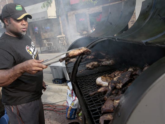 Patrick Rashed cooks jerk chicken at the Caribbean Kitchen tent at the Iowa Arts Festival on June 1, 2012. The food vendor returns to the 2016 festival June 3-5, 2016.