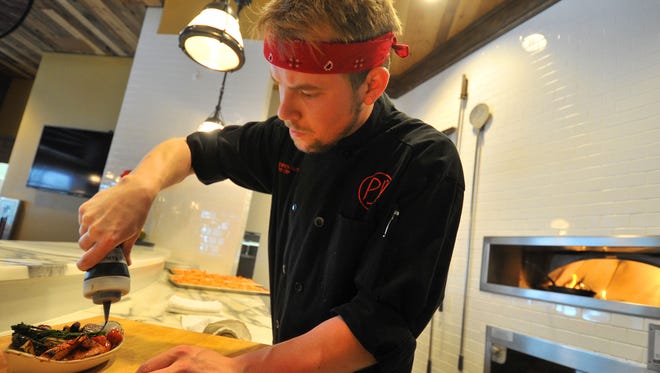 Chef Brandon McCormick-Guthu prepares a vegetable dish Thursday by PJ's at Sentry World in Stevens Point.