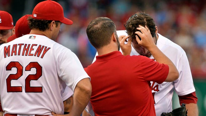 St. Louis Cardinals starting pitcher Lance Lynn (31) is checked out by a trainer after he was hit in the head with a line drive off the bat of Kansas City Royals center fielder Lorenzo Cain (not pictured) during the third inning at Busch Stadium.