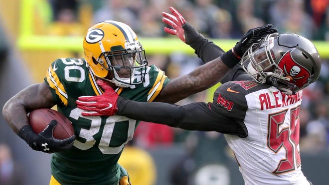 Green Bay Packers running back Jamaal Williams (30) stiff arms Tampa Bay Buccaneers middle linebacker Kwon Alexander (58) in overtime on December 3, 2017, at Lambeau Field in Green Bay, Wis. The Green Bay defeated Tampa Bay 26-20.