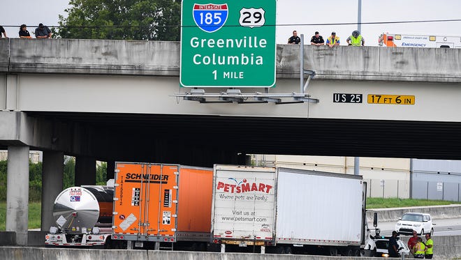 Tractor trailers sit parked under a bridge on I-85 at White Horse Road where a man had threatened to jump Saturday, July 7, 2018.