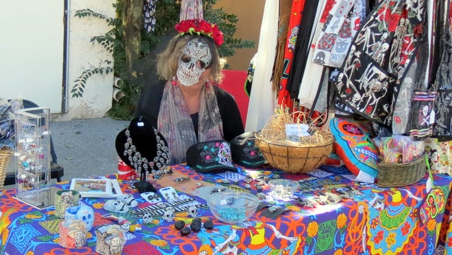 Pictured is costumed craft vendor at 2015 Dias de los Muertos event.
