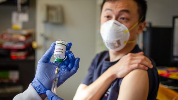 Man getting COVID-19 vaccine from doctor.
