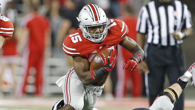 Ohio State University's Ezekiel Elliott makes a bid gain against the University of Cincinnati during the third quarter of their game played at Ohio State in Columbus, Ohio Saturday September 27, 2014. The Enquirer/Gary Landers