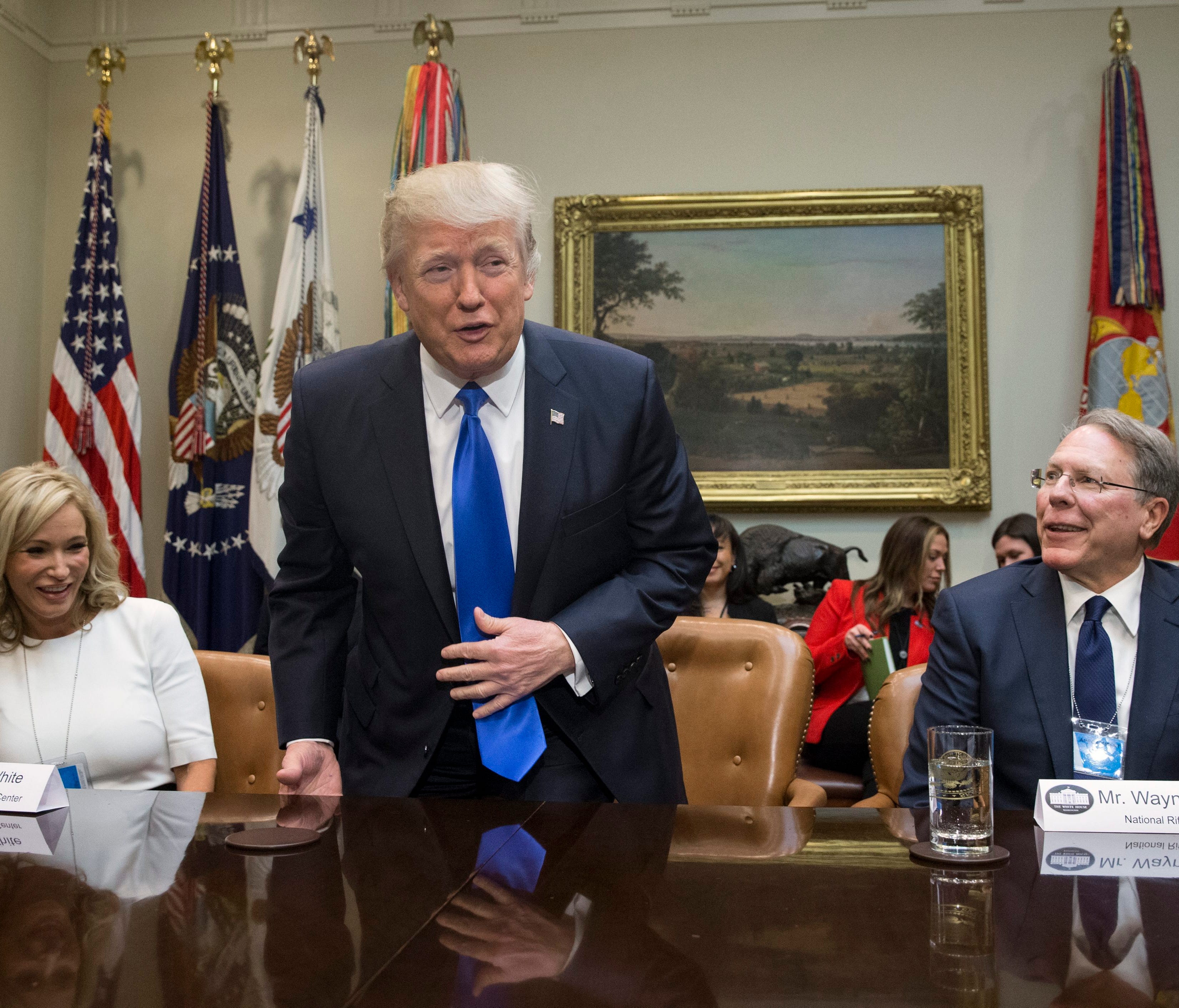 Trump takes his seat between Paula White of the New Destiny Christian Center and NRA Executive Vice President and CEO Wayne LaPierre at a meeting on his nomination of Neil Gorsuch to the Supreme Court in the Roosevelt Room on Feb. 1, 2017.