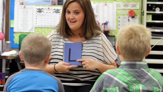 Stephanie Bosh uses letter flash cards to help students recognize letters in kindergarten at Pleasant Elementary School in Marion in this file photo.