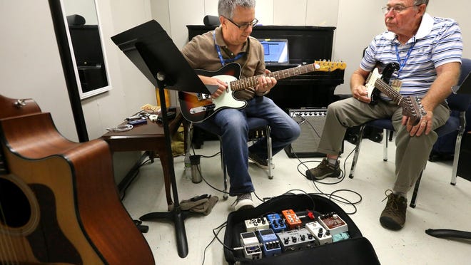 Michael McElravy, left, gives guitar lessons to Norman Pope, right, during the Stamps-Baxter School of Music at MTSU Wednesday, July 22, 2015.