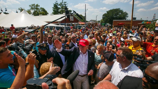 Republican presidential candidate Donald Trump is surrounded by fairgoers at the Iowa State Fair on Saturday.