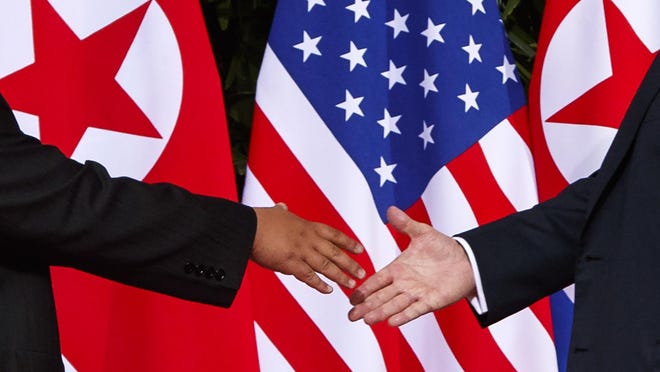 In this June 12, 2018, file photo, President Donald Trump, right, reaches to shake hands with North Korea leader Kim Jong Un at the Capella resort on Sentosa Island in Singapore.