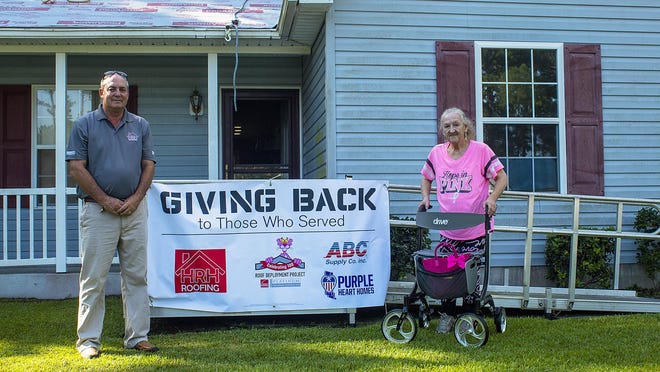 Ras Homes, owner of HRH Roofing and U.S. Air Force veteran Barbara Potter stand outside Potter's Havelock home. Potter is receiving a new roof through cooperation with  Owens Corning, Purple Heart Homes and HRH Roofing.