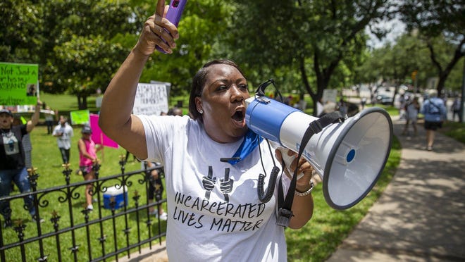 Loving Igbani of Houston chants "Parole, not death roll" as she joins other family members protesting for the release of prison inmates at risk of contracting the coronavirus behind bars. [RICARDO B. BRAZZIELL/AMERICAN-STATESMAN]\r\r