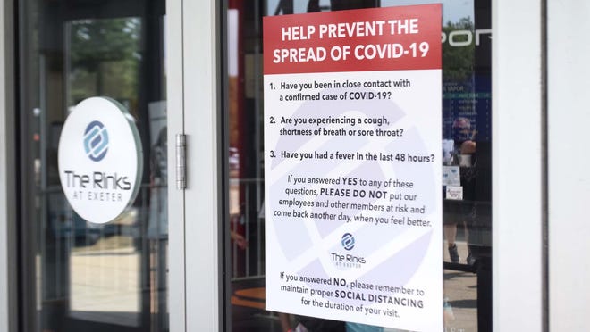 A sing at the Rinks at Exeter reminds of COVID-19 precautions. Public health officials in multiple northeastern U.S. states are investigating the possible spread of the coronavirus among youth hockey players.