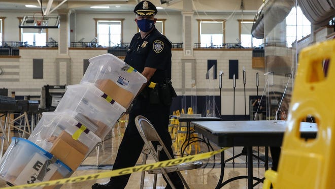 Franklin Police Chief Thomas Lynch brings in sealed ballots during the counting of uncounted ballots from Tuesday's primary election on Thursday afternoon at Franklin High School. Counting wasn't complete until early Friday morning.