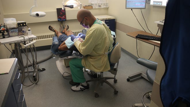 Dr. Kartik Antani works with a patient at the Monmouth Family Health Center’s current smaller facility within Monmouth Medical Center in Long Branch. Health officials are putting the finishing touches on a dental clinic on Broadway for the health center that is set to open in early September.
