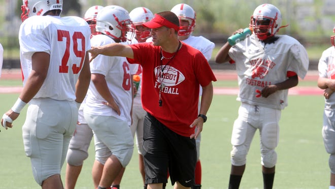 Perth Amboy first year football coach Brad Bishop works with his players during preseason practice, Wednesday, August 20, 2014, in Perth Amboy, NJ. Photo by Jason Towlen
