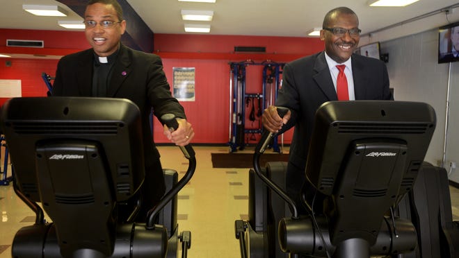 Lane College President Logan Hampton and Executive Vice President Moses Goldman try out new exercise equipment Wednesday at the college’s new fitness center.