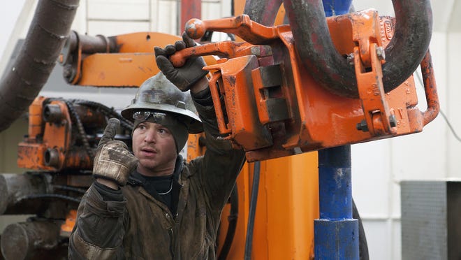 
Russell Girsh motions to his driller to turn the equipment on at an oil rig near Watford City, N.D. Oil and gas workers earned an average 11
percent more an hour in April than they did a year ago, according to the Bureau of Labor Statistics. 
