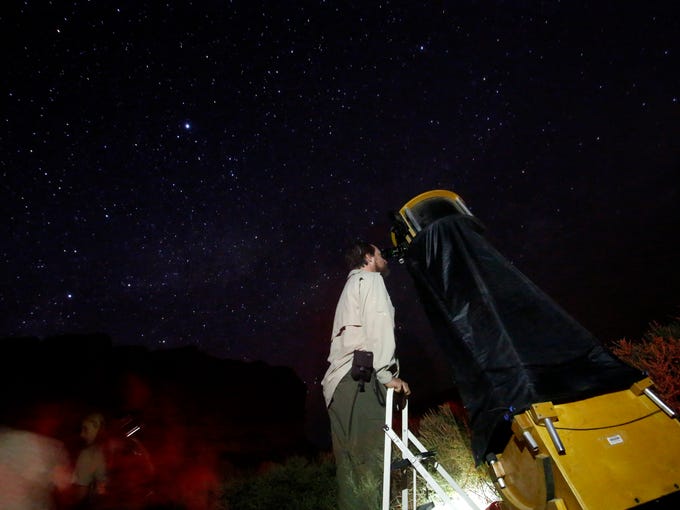 Don Emerson of Austin looks through a telescope during