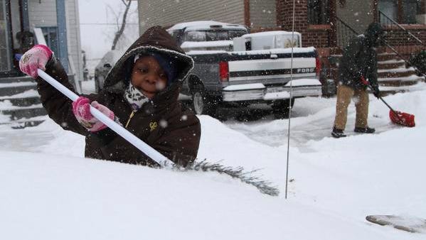 Derreana Combs, 10, brushes snow off of her mothers car at their 41st St. home in Louisville, Ky.  February 16, 2015.
