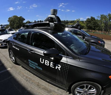 A group of self driving Uber vehicles position themselves to take journalists on rides during a media preview at Uber's Advanced Technologies Center in Pittsburgh.