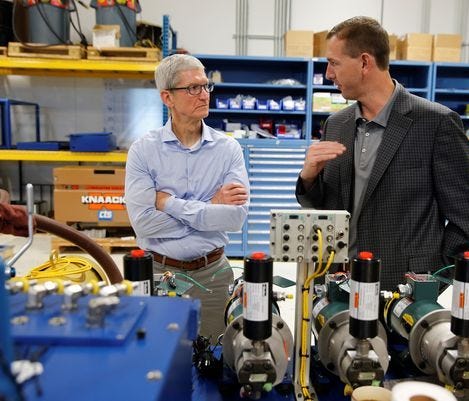 Apple CEO Tim Cook listens to Cincinnati Test Systems president Kevin Hansell during a visit of the Harrison factory.