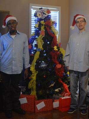 Kevin Ross Jr. and David Bernard Jr. pose in front of their “tree of hope,” an Autism Awareness tree the two decorated with the help of Kevin’s mother and their house manager, Linda Chism.