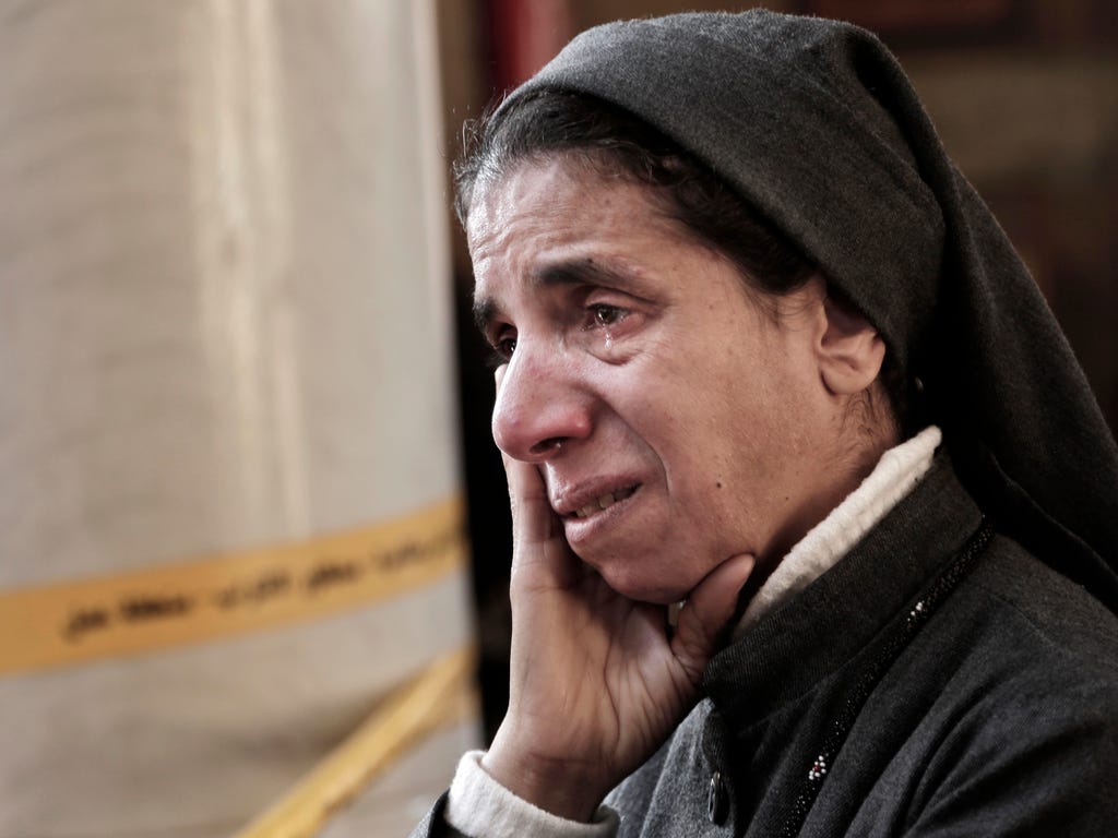 An Egyptian Coptic nun weeps as she looks at damages inside the St. Mark Cathedral in central Cairo, following a bombing. The blast at Egypt's main Coptic Christian cathedral killed dozens of people and wounded many others, according to Egyptian stat
