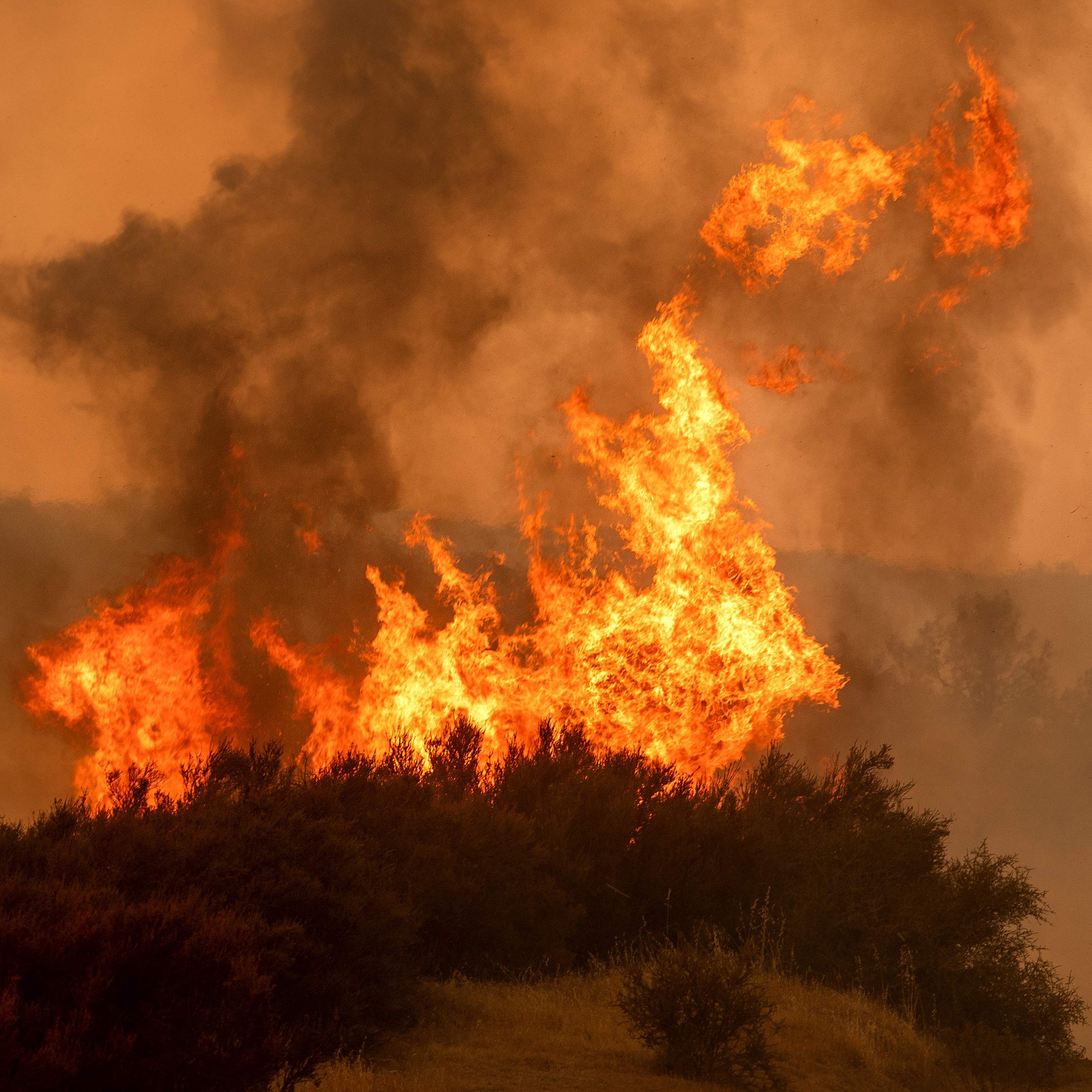 Flames leap above a vehicle on High Valley Rd. as the Ranch Fire, part of the Mendocino Complex Fire, burns near Clearlake Oaks, Calif., on August 5, 2018.  Several thousand people have been evacuated as various fires swept across the state, although 