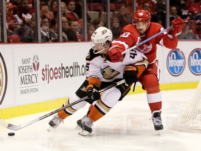 The Red Wings' Henrik Zetterberg, right, tries to pull