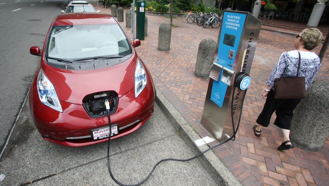 A Nissan Leaf charges at a electric vehicle charging station in Portland, Ore.