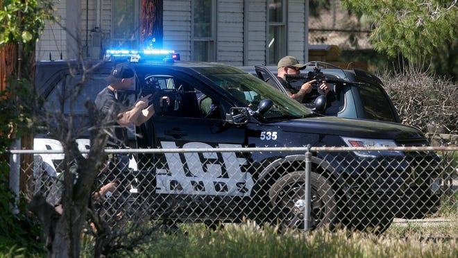 Redlands Police Department officers train guns on a suspect who had taken a hostage outside a home following a shooting incident at a nearby Office Depot store, in Redlands, Calif., Thursday, Mar. 24, 2016. Police have shot and killed a man they say took his ex-girlfriend hostage after a shooting at an Office Depot in Redlands. (David Bauman/The Press-Enterprise via AP)