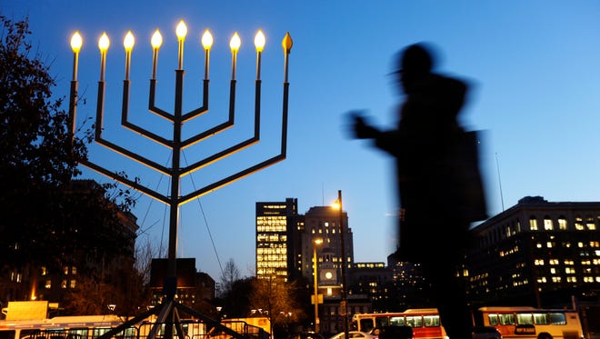A woman passes a large menorah on Independence Mall on the seventh ...