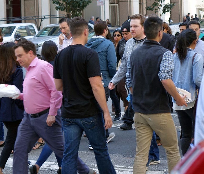 A crowd of workers cross the street in San Francisco. The H1-B visa changes heavily effect tech the tech industry.