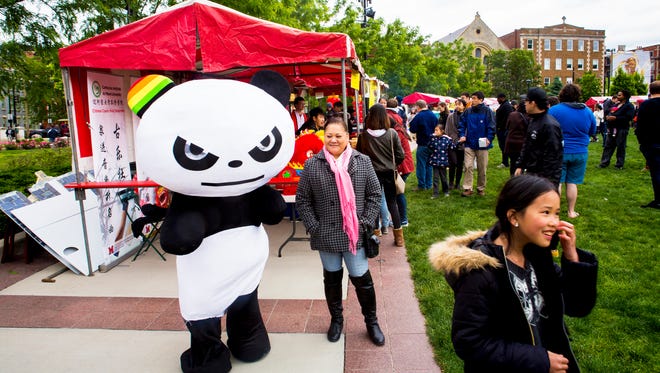 A panda character waits to pose for photos with the crowd at The Asian Food Fest at Washington Park Saturday, May 14, 2016. 