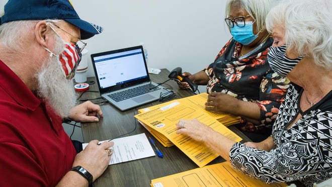 Bob Teel, left, Dorothy Williams and Joanna Dodd verify voter signatures on ballot envelopes at the Sangamon County Building Tuesday, Sept. 29, 2020. If all three agree that a signature doesn't match, the voter is notified so they can address any errors.