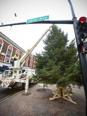 Crews use a crane to raise a 25-foot tree into place Tuesday, Nov. 29, at the intersection of 10th Avenue and St. Germain Street in St. Cloud. The tree will be part of the St. Cloud Downtown Council's Winter Nights & Lights Festival.