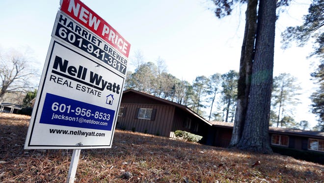 A realty sign is posted in front of a home for sale in Jackson, Miss.