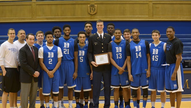 In this Jan. 23, 2015, photo provided by the Duke University Sports Information Department, Duke basketball player Marshall Plumlee poses with other members of the Duke University basketball team after his Army Reserve Officers' Training Corps (ROTC) contracting ceremony, before a team practice at Cameron Indoor Stadium in Durham, N.C.