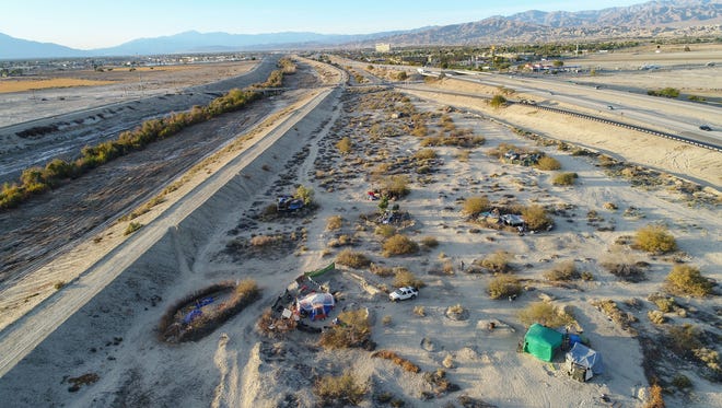 Homeless campsites dot the landscape on a wedge of land owned by Caltrans where Dillon Road meets Highway 86 in Coachella.