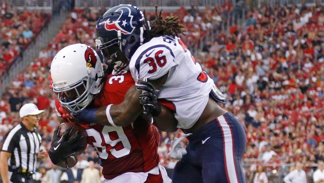 Arizona Cardinals running back Robert Hughes (39) tries to break free from Houston Texans strong safety D.J. Swearinger (36) during the first half of  their NFL preseason game Saturday, Aug. 9,  2014 in Glendale, Ariz.