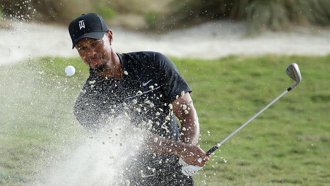 Tiger Woods hits from a bunker onto the 14th green during the first round at the Hero World Challenge golf tournament, Thursday, Dec. 1, 2016, in Nassau, Bahamas. Woods is one-over-par for the round. (AP Photo/Lynne Sladky)